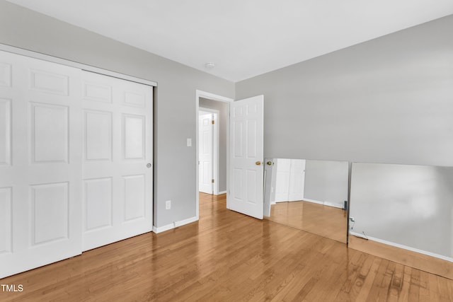 unfurnished bedroom with wood-type flooring and a closet