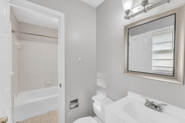 full bathroom featuring tiled shower / bath, vanity, and toilet