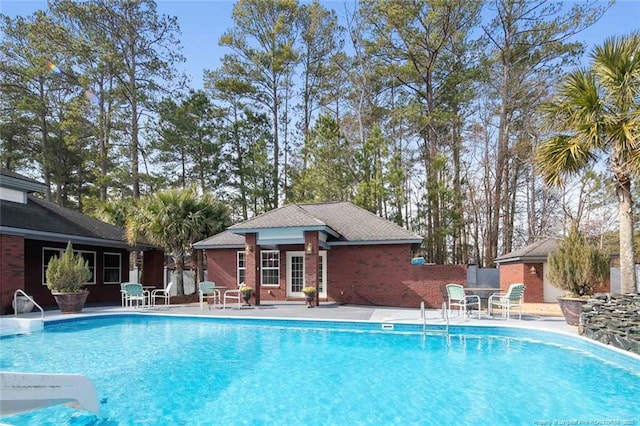 view of swimming pool featuring an outdoor structure and a patio