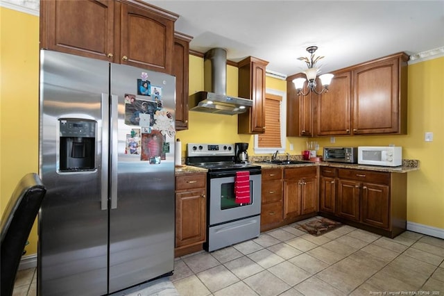 kitchen with sink, dark stone countertops, stainless steel appliances, wall chimney exhaust hood, and a chandelier