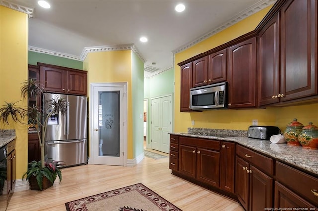 kitchen with light stone countertops, appliances with stainless steel finishes, and light wood-type flooring