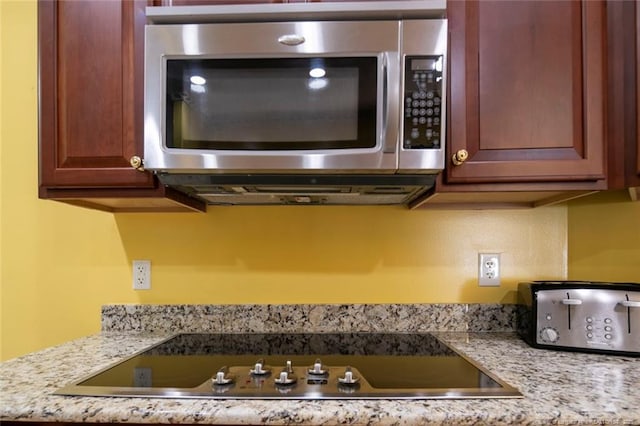 interior details featuring black electric cooktop and light stone countertops