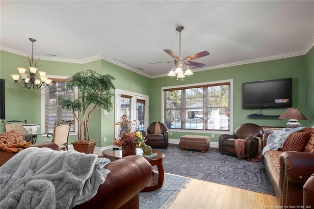 living room with ornamental molding, wood-type flooring, and ceiling fan with notable chandelier