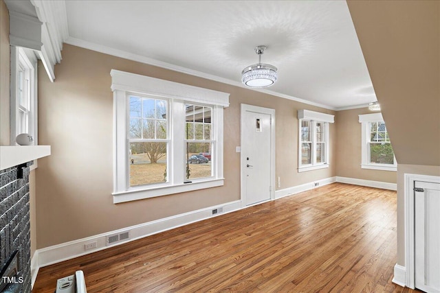 unfurnished living room with crown molding and hardwood / wood-style floors