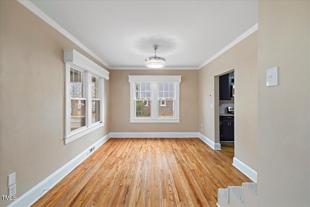 unfurnished dining area with crown molding and light hardwood / wood-style flooring