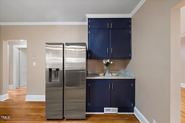 kitchen featuring hardwood / wood-style floors, crown molding, stainless steel fridge, and blue cabinetry