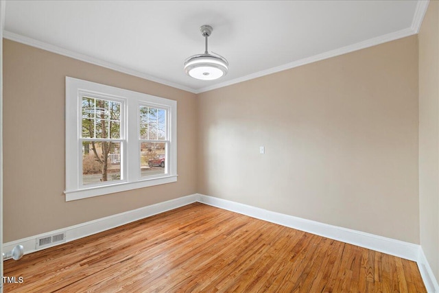 spare room featuring crown molding and light hardwood / wood-style floors