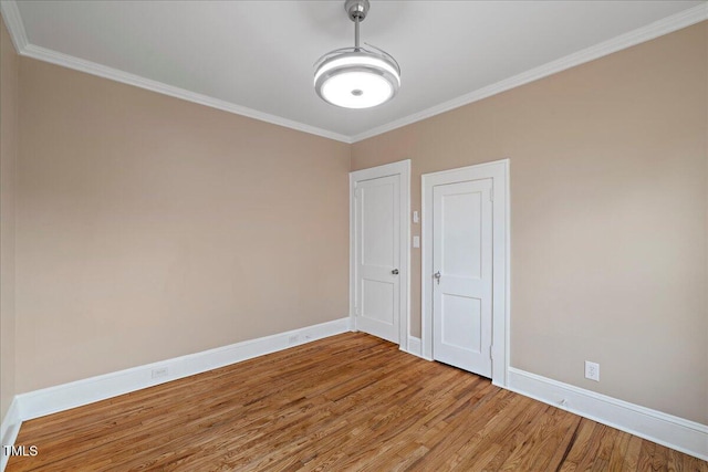 empty room with ornamental molding and light wood-type flooring