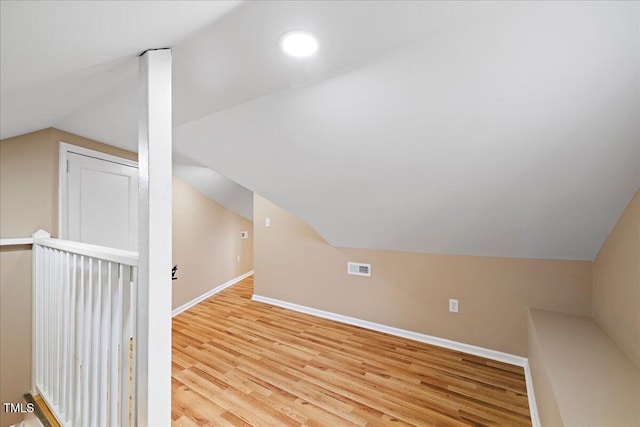 additional living space featuring lofted ceiling and light hardwood / wood-style floors