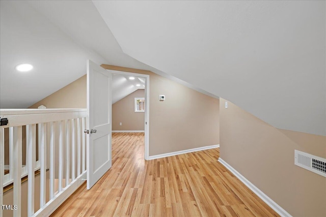 bonus room featuring vaulted ceiling and light wood-type flooring