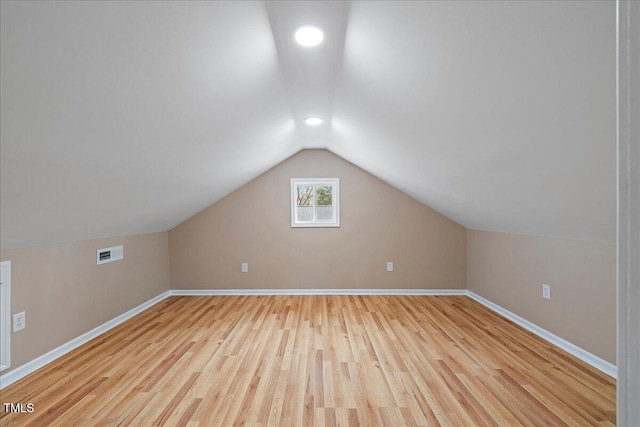 bonus room with lofted ceiling and light hardwood / wood-style flooring