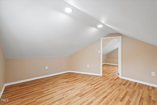 additional living space featuring lofted ceiling and light hardwood / wood-style floors