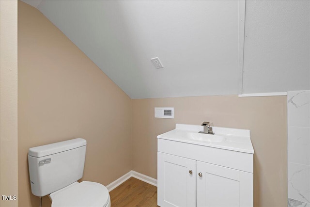 bathroom featuring vanity, toilet, vaulted ceiling, and hardwood / wood-style floors