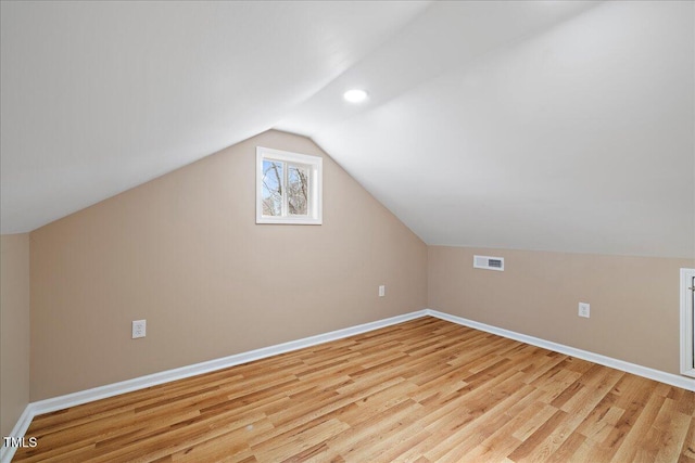 additional living space with lofted ceiling and light wood-type flooring