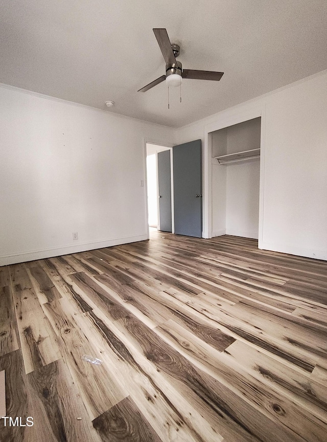 unfurnished bedroom with wood-type flooring, a closet, and ceiling fan