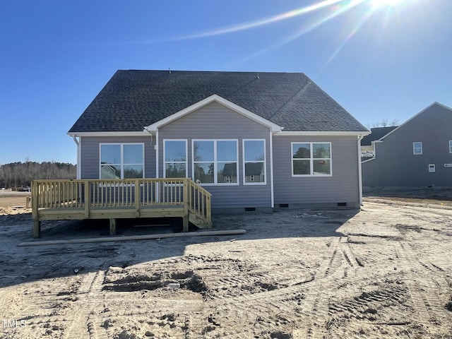 rear view of house with a shingled roof, crawl space, and a deck