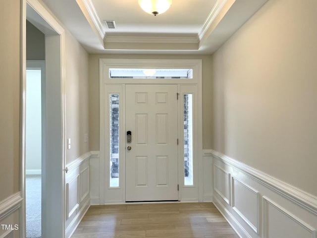 82 N Stagecoach Dr, Wendell, NC 27591 - entrance foyer featuring healthy amount of natural light, a decorative wall, light wood finished floors, ornamental molding, and a raised ceiling