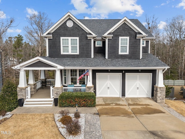 craftsman inspired home featuring a porch, a garage, driveway, and roof with shingles