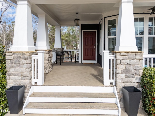 property entrance featuring covered porch and stone siding