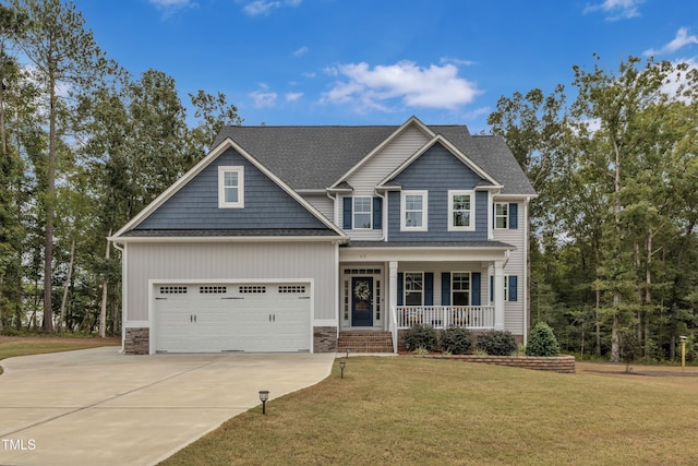 craftsman house with a garage, covered porch, and a front lawn