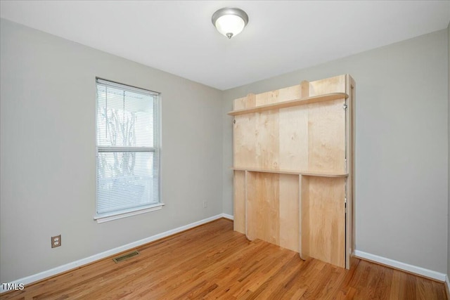 unfurnished bedroom with wood-type flooring and a closet