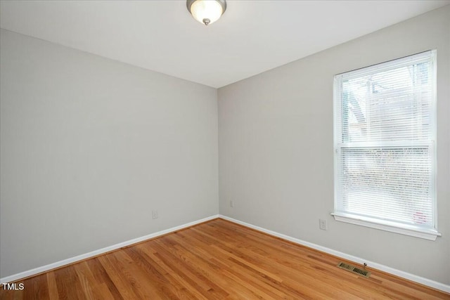 empty room with a healthy amount of sunlight and light hardwood / wood-style floors