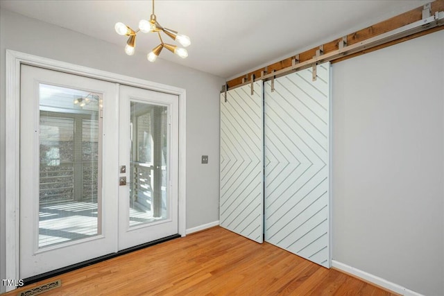 entryway with french doors, a chandelier, and hardwood / wood-style flooring