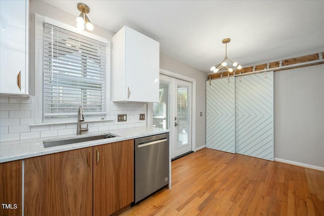 kitchen with sink, dishwasher, white cabinetry, tasteful backsplash, and decorative light fixtures