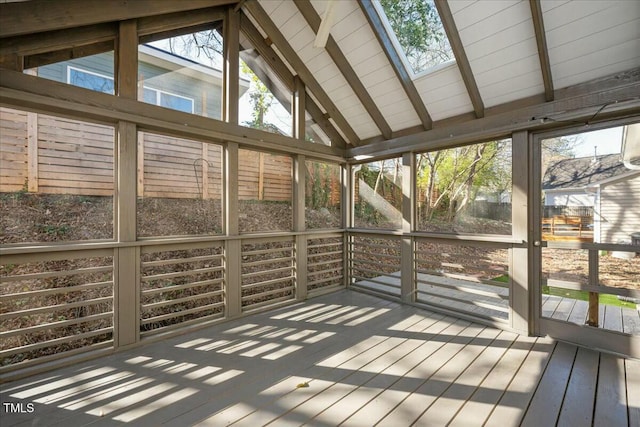 unfurnished sunroom featuring lofted ceiling with skylight