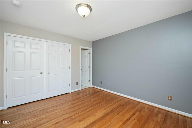 unfurnished bedroom featuring light hardwood / wood-style floors and a closet