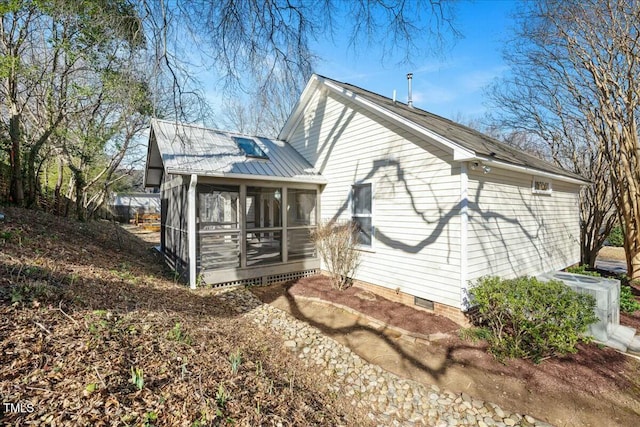 rear view of property with central AC unit and a sunroom