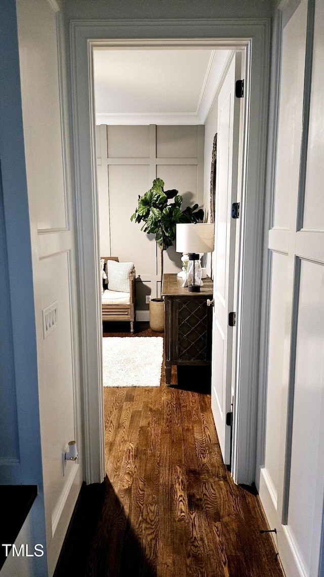 hall featuring dark wood-type flooring and ornamental molding