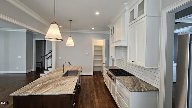 kitchen featuring pendant lighting, an island with sink, glass insert cabinets, and white cabinetry