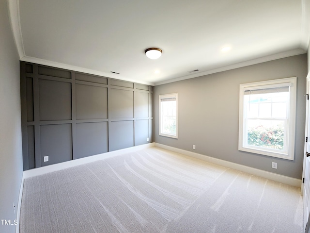 unfurnished bedroom with light carpet, multiple windows, and ornamental molding