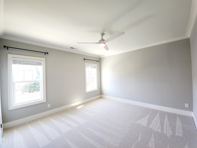 unfurnished room featuring baseboards, light colored carpet, visible vents, and crown molding