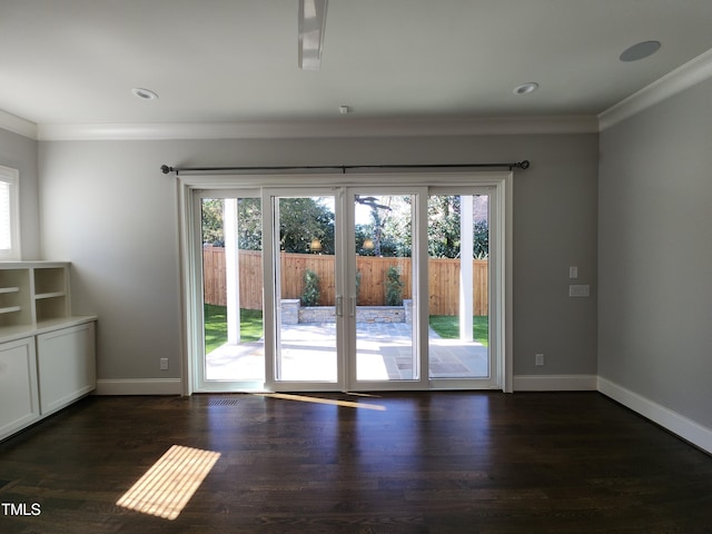 interior space with a healthy amount of sunlight, baseboards, dark wood-type flooring, and crown molding