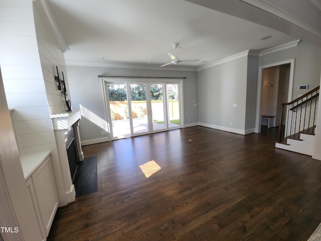 unfurnished living room featuring dark wood-style floors, crown molding, ceiling fan, baseboards, and stairs