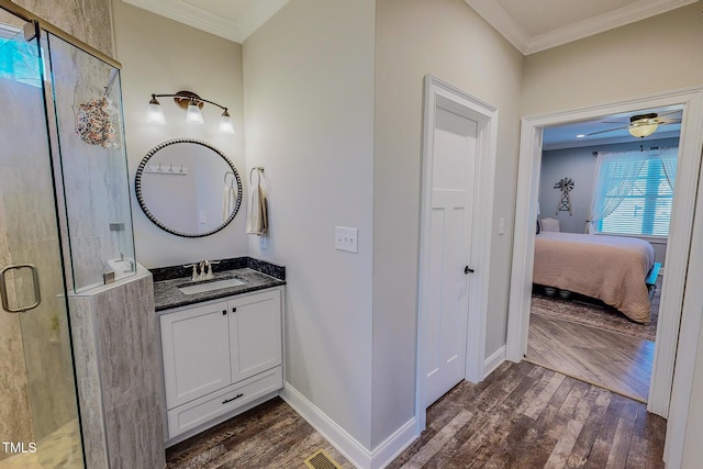 bathroom with hardwood / wood-style flooring, crown molding, vanity, and a shower with shower door