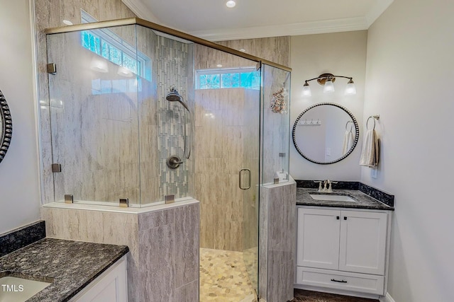 bathroom with a shower with door, vanity, and crown molding