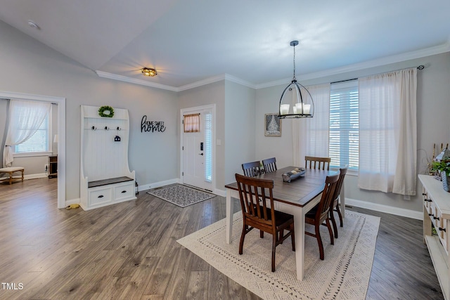 dining space featuring a notable chandelier, dark wood-type flooring, ornamental molding, and plenty of natural light