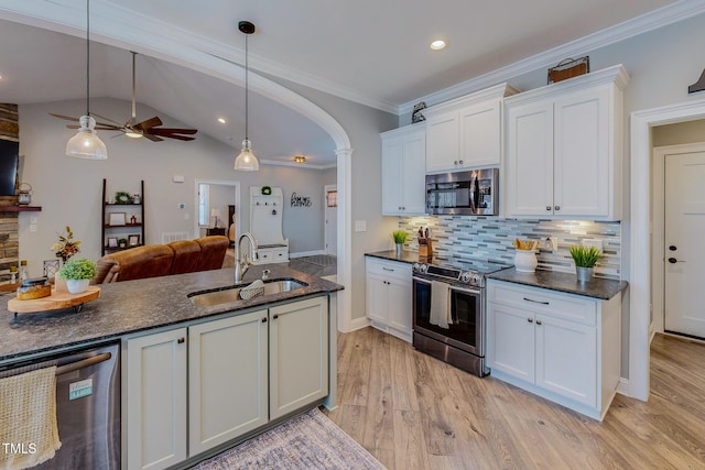 kitchen with decorative light fixtures, white cabinetry, sink, light hardwood / wood-style floors, and stainless steel appliances