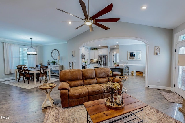 living room with lofted ceiling, ceiling fan, and light wood-type flooring