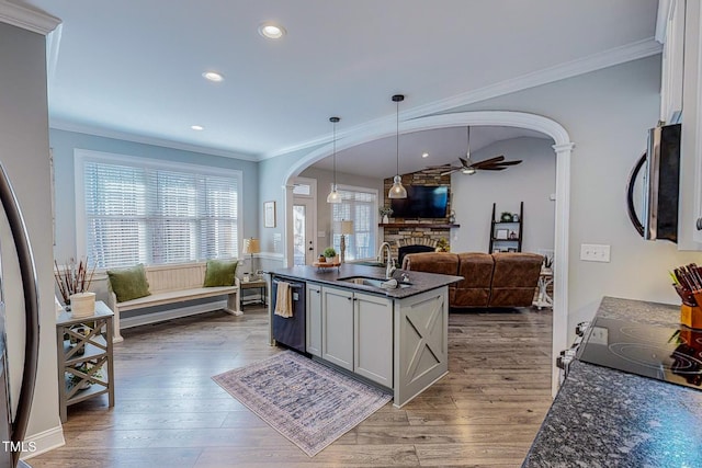 kitchen with pendant lighting, sink, black dishwasher, a fireplace, and dark hardwood / wood-style flooring