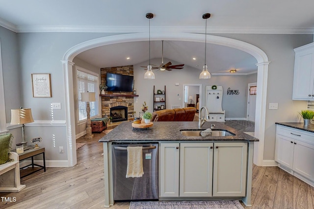 kitchen with sink, a kitchen island with sink, white cabinets, decorative light fixtures, and stainless steel dishwasher