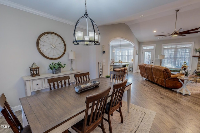 dining area featuring ceiling fan with notable chandelier, lofted ceiling, a healthy amount of sunlight, and light hardwood / wood-style floors