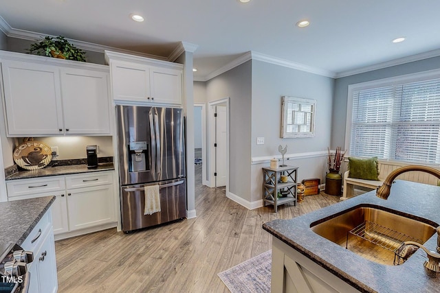 kitchen featuring white cabinetry, sink, light hardwood / wood-style floors, and stainless steel fridge with ice dispenser