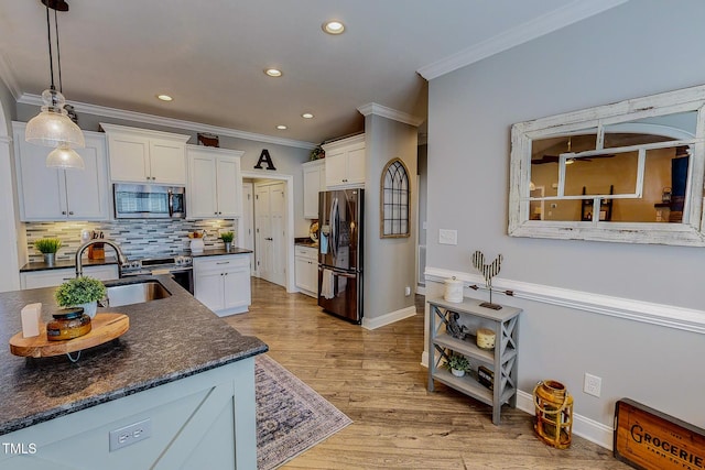 kitchen with black fridge with ice dispenser, sink, hanging light fixtures, light hardwood / wood-style floors, and white cabinets