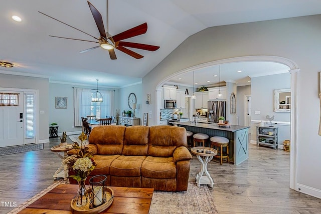 living room with lofted ceiling, sink, crown molding, ceiling fan, and hardwood / wood-style floors