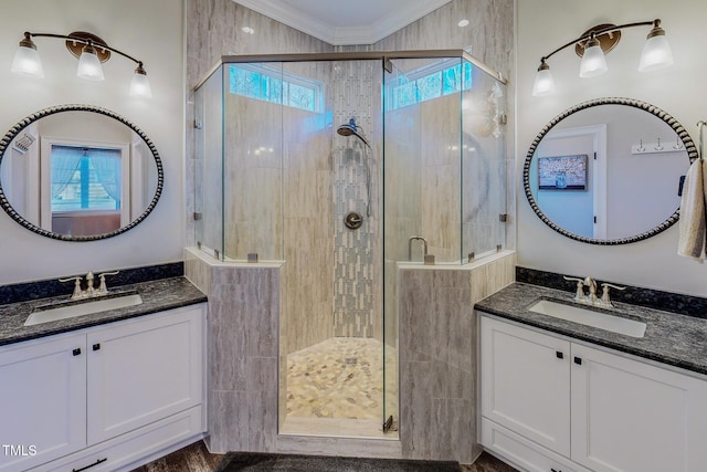 bathroom featuring vanity, a shower with shower door, and ornamental molding