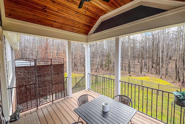 unfurnished sunroom featuring wood ceiling, ceiling fan, plenty of natural light, and vaulted ceiling